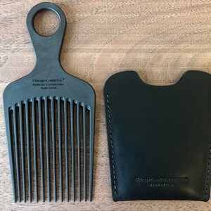 Może przedstawiać: Czarny grzebień z uchwytem i sk&oacute;rzanym etui. Grzebień jest oznaczony "Chicago Comb Co. Model No. 7 Carbon Fiber Made in USA". Etui jest oznaczone "Chicago Comb Co. Made in USA".