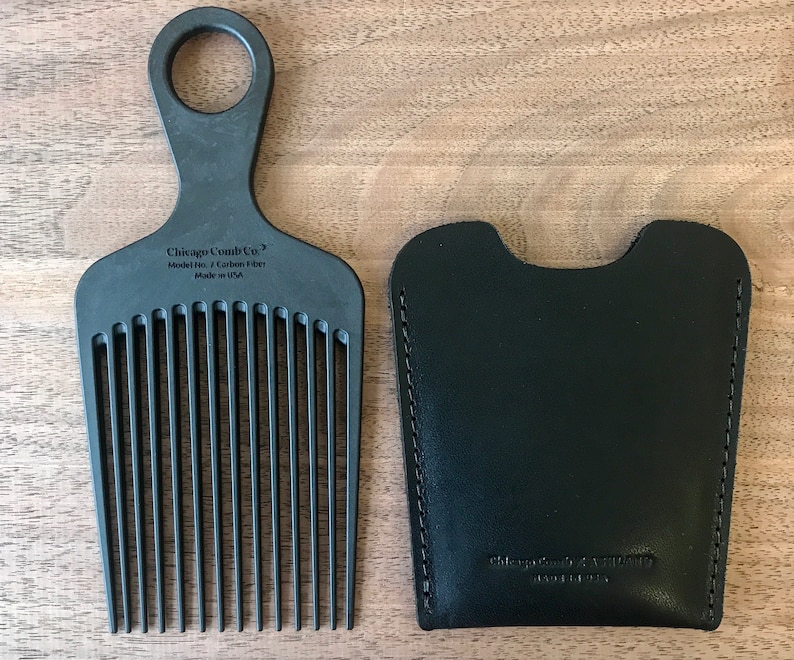 Może przedstawiać: Czarny grzebień z uchwytem i sk&oacute;rzanym etui. Grzebień jest oznaczony "Chicago Comb Co. Model No. 7 Carbon Fiber Made in USA". Etui jest oznaczone "Chicago Comb Co. Made in USA".