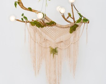 Luminaire lustre en macramé sur une branche d'arbre avec de la mousse