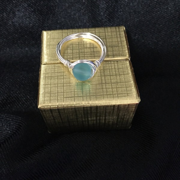 Anillo de plata de ley o chapado en oro con cristal marino azul y engastado con alambre.