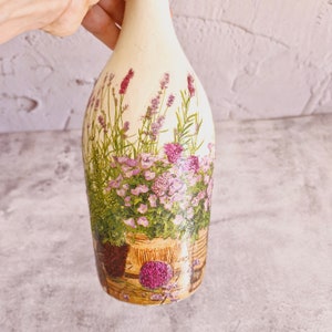 Upcyled wine bottle painted in white and decoupaged with flowers