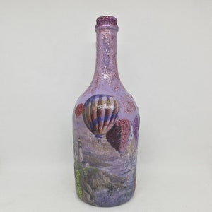 Upcyled wine bottle painted in violet  and decoupaged with a picture of balloons.