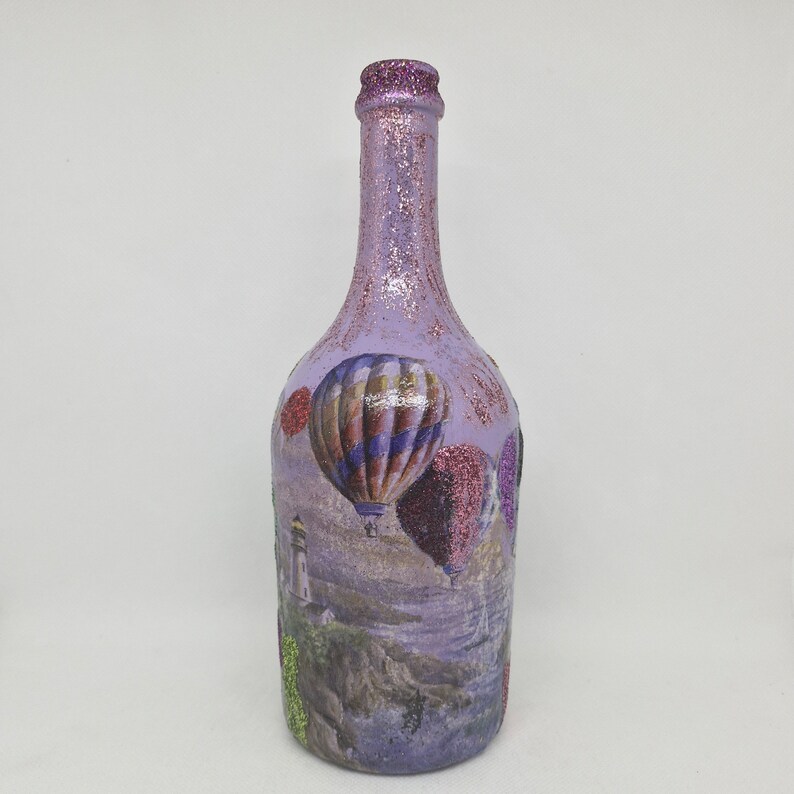 Upcyled wine bottle painted in violet  and decoupaged with a picture of balloons.
