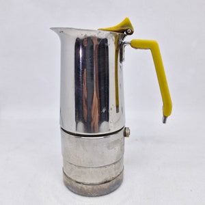 Pode incluir: Uma cafeteira de espresso de aço e amarela com uma alça e uma tampa amarelas.