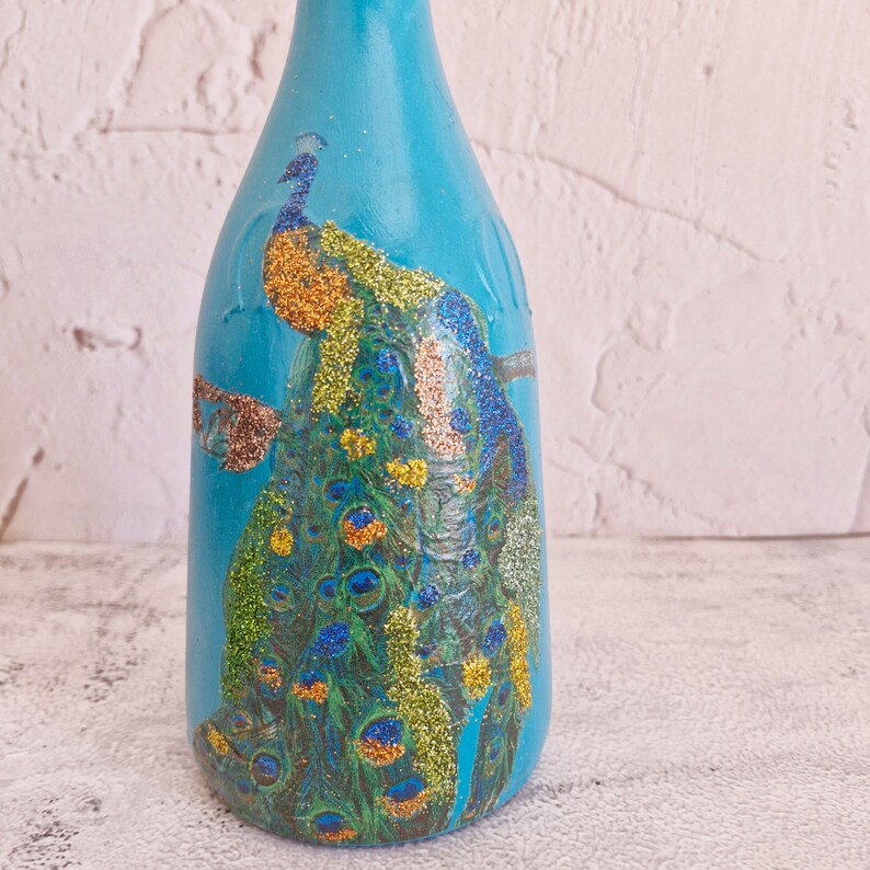 Upcyled wine bottle painted in turquoise  and decoupaged with pecock