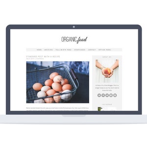 以下が含まれることがあります： 「オーガニックフード」というタイトルのウェブサイトと、「標準的なレシピ付き投稿」というタイトルのブログ記事が表示されているラップトップコンピューター。記事には、茶色の卵が入ったバスケットの写真と、「About Me」というテキストのサイドバーが表示されています。