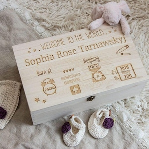 May include: A wooden keepsake box with an engraved inscription that reads "Welcome to the world. Sophia Rose Tarnawskyj. Born at 2:56PM. Weighing 6LB7OZ. On the 20th May 2011. Newcross Hospital." The box has a small brass latch and is decorated with stars, hearts, and a clock, scale, and hospital cross.