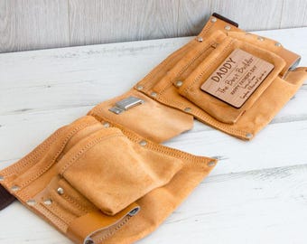 May include: A brown leather tool belt with multiple pockets and a wooden plaque that reads "Daddy The Best Builder Happy Father's Day".