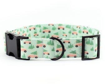 May include: A green dog collar with a pattern of pink cars carrying Christmas trees. The collar has a black buckle and a black D-ring.