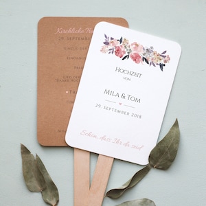 Könnte beinhalten: Ein weißer Hochzeitsfächer mit floralem Design und dem Text "Hochzeit von Mila & Tom 29. September 2018" und "Schon, dass Ihr da seid".