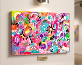May include: A rectangular canvas painting featuring an abstract composition of vibrant pink, yellow, orange, blue, and green paint strokes. The artwork includes white circular outlines, black sun-like shapes, and a small plaque labeled Joyful Energy.