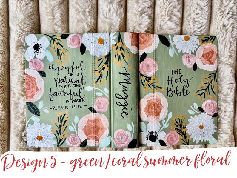 May include: A green Bible cover with coral, white, and yellow floral patterns. The cover has the text "Be joyful in hope, patient in affliction, faithful in prayer - Romans 12:12" and "The Holy Bible". The name "Maggie" is written on the spine.