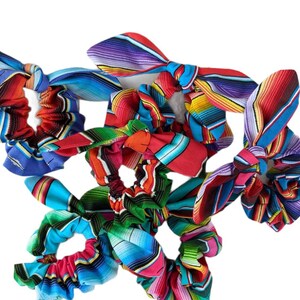 Puede incluir: Una colecci&oacute;n de coloridas gomas para el pelo con lazos anudados. Las gomas presentan un vibrante estampado de rayas en tonos de azul, rojo, verde, naranja y morado. Estos accesorios para el cabello son perfectos para a&ntilde;adir un toque de color a cualquier peinado.