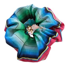 May include: A colorful scrunchie with a striped pattern in shades of blue, green, pink, and yellow. The scrunchie is made of fabric and has a gathered look.