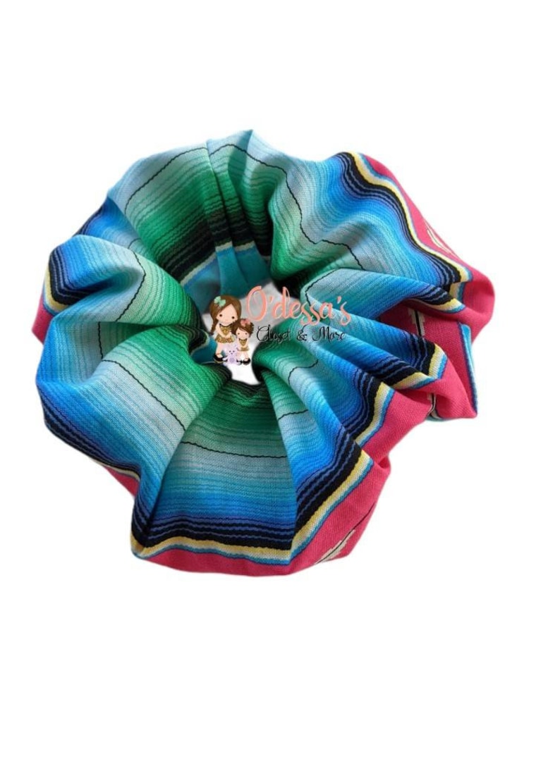 May include: A colorful scrunchie with a striped pattern in shades of blue, green, pink, and yellow. The scrunchie is made of fabric and has a gathered look.