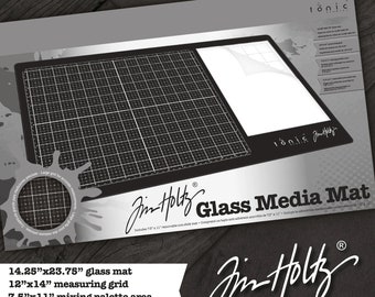 May include: A black glass media mat with a gridded measuring area and a non-stick mat. The mat is 14.25 inches by 23.75 inches. The mat is made by Jin Holtz.