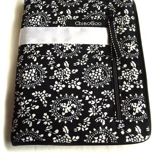 May include: Black and white floral patterned laptop sleeve with a white zipper pull and a white satin ribbon with the text "ChiaoGoo" embroidered on it.