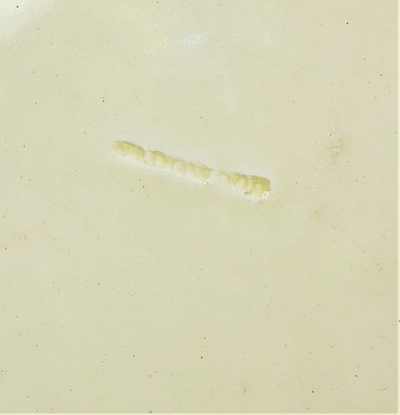 May include: A close-up of a light beige surface with a thin, light yellow line running across it.