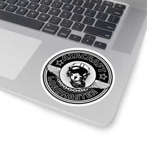 Puede incluir: Una pegatina circular en blanco y negro con un gráfico central de una calavera con casco de vuelo y gafas, flanqueada por alas y cadenas, con el texto AIRCRAFT LOADMASTER arqueado alrededor del borde y dos pequeñas estrellas.