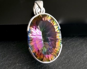 May include: A silver pendant featuring a large, oval-shaped, iridescent gemstone with a faceted cut. The gemstone displays a rainbow of colors, including pink, purple, blue, green, and yellow.