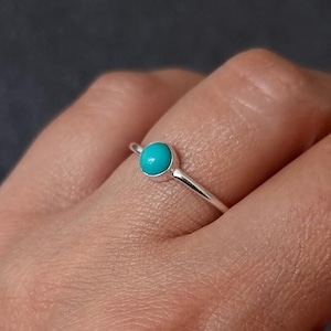 Puede incluir: Un anillo de plata con una piedra turquesa. El anillo es simple y elegante, perfecto para el uso diario.