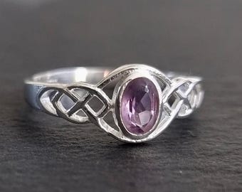 May include: A silver ring featuring a Celtic knot design and a purple oval gemstone.