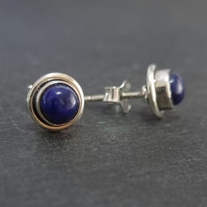 Peut inclure: Une paire de boucles d'oreilles en argent avec une pierre de lapis-lazuli bleu foncé sertie dans chaque boucle d'oreille.