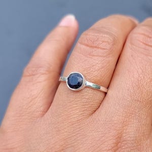 May include: A silver ring with a round black gemstone.