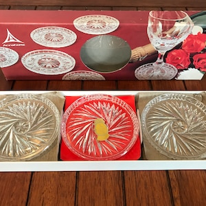 May include: Set of six clear glass coasters with a starburst pattern. The coasters are packaged in a red and white box with the brand name "Annabelle" printed on the front.