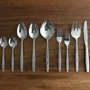 May include: A set of silverware with a floral design on the handles. The set includes spoons, forks, and knives.