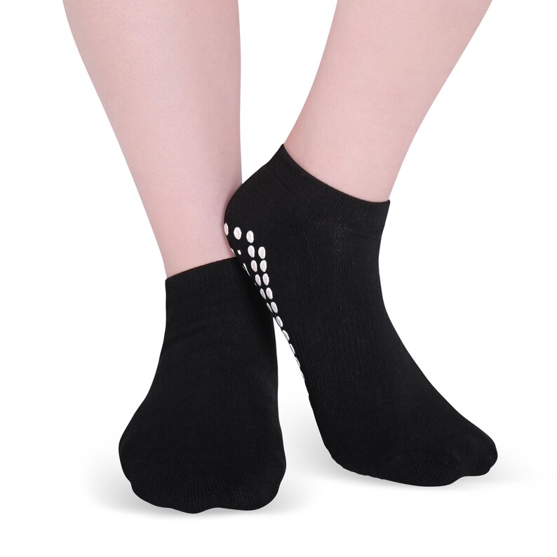 May include: A pair of black ankle socks with white grippy dots on the bottom. The socks are made of a soft, comfortable material and are ideal for yoga, Pilates, or other activities where you need to grip the floor.