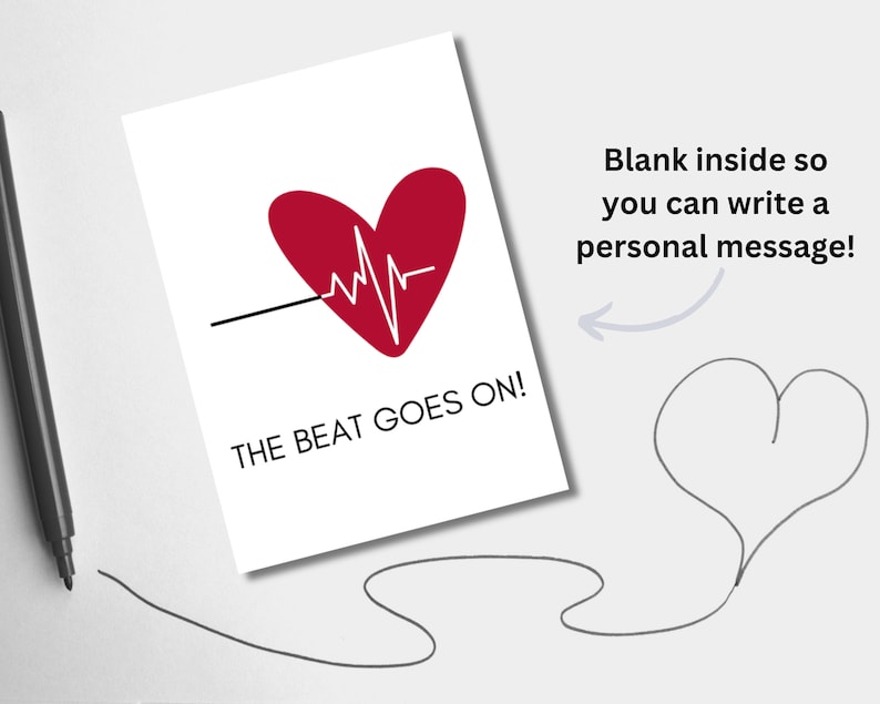 May include: A white card with a red heart and a black line with a white EKG line running through it. The text "THE BEAT GOES ON!" is printed below the heart. The card is blank inside for writing a personal message.