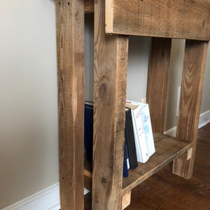 May include: Rustic wooden side table with a shelf, featuring a distressed brown finish. The table has a single shelf and is made of reclaimed wood.