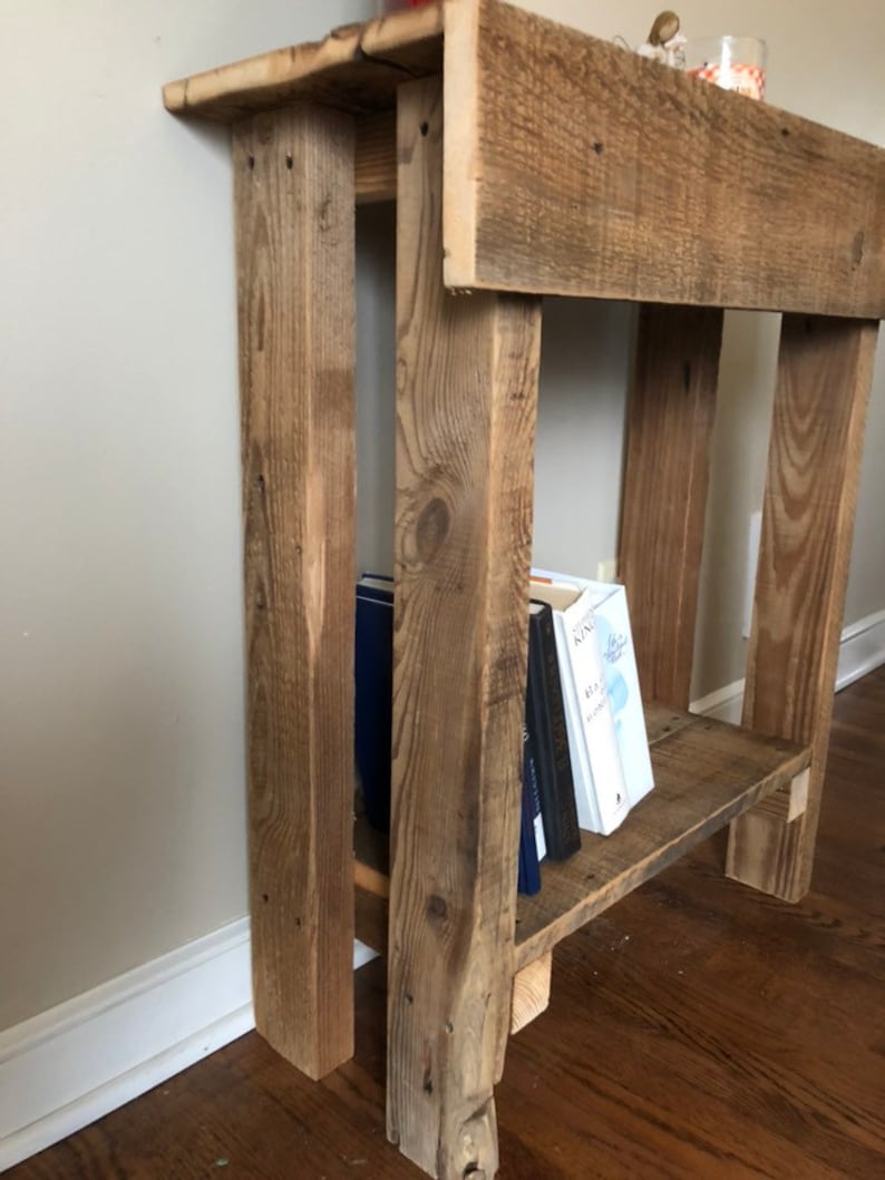 May include: Rustic wooden side table with a shelf, featuring a distressed brown finish. The table has a single shelf and is made of reclaimed wood.