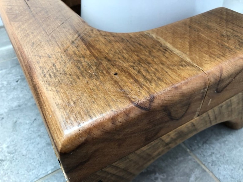 May include: Close-up of a wooden corner of a rustic bench, showing the natural grain and texture of the wood.