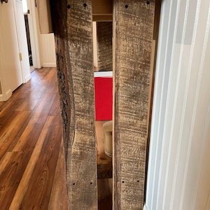 May include: A rustic wooden console table with a natural wood finish. The table has a simple design with two legs and a rectangular top. The table is made of reclaimed wood and has a distressed look.