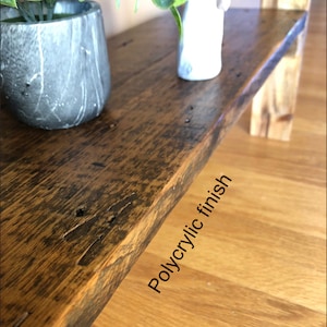May include: A close-up of a wooden shelf with a natural wood finish. The shelf has a light brown color and a smooth surface. The shelf is made of reclaimed wood and has a rustic look. The shelf is finished with a clear polyacrylic finish.