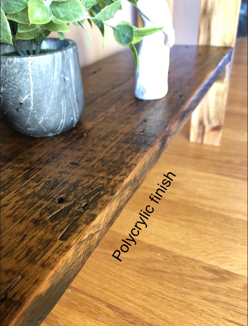 May include: A close-up of a wooden shelf with a natural wood finish. The shelf has a light brown color and a smooth surface. The shelf is made of reclaimed wood and has a rustic look. The shelf is finished with a clear polyacrylic finish.