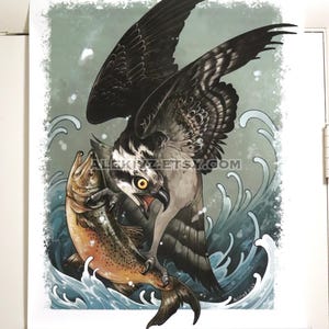May include: A poster print featuring an osprey with outstretched wings clutching a fish. The bird has detailed black and white feathers, a yellow eye, and an open beak. The fish is brown and orange, set against a backdrop of stylized waves and a teal sky.