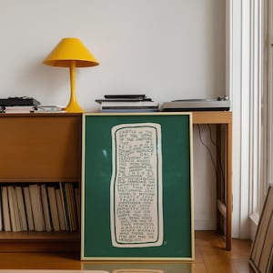 Puede incluir: Una obra de arte verde enmarcada con una lista de t&iacute;tulos en texto blanco. Una l&aacute;mpara amarilla con una pantalla redondeada se encuentra sobre un mueble de madera. La obra de arte se exhibe en una habitaci&oacute;n con una ventana y un tocadiscos.