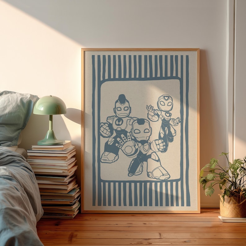May include: A framed print showcasing three blue robot figures in a stylized design. The artwork is set against a cream background with a blue striped border, within a wooden frame. The print is displayed on a wooden floor.