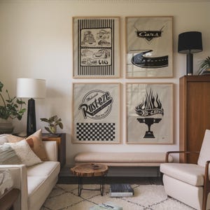 May include: Four framed art prints with black and white car-themed designs. One print features a road, another has the word "Cars" in a logo, and a third displays "Rusteze" with a checkered pattern. The fourth print shows a trophy.