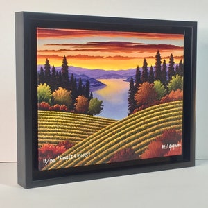 May include: A framed painting depicting a sunset over a vineyard with a lake in the distance. The painting is titled "Sunset & Vines" and is numbered 18/150. The artist's signature is in the bottom right corner.