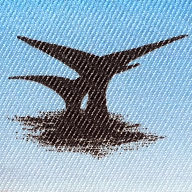 Op de afbeelding: Een zwart silhouet van twee walvissen die uit het water springen tegen een lichtblauwe achtergrond.