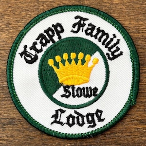 Könnte beinhalten: Gestickter Aufnäher mit weißem Hintergrund und grünem Rand. Der Aufnäher zeigt die Worte "Krapp Family Stowe Lodge" in schwarzer Schrift um einen grünen Kreis mit einer goldenen Krone.