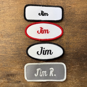 May include: Four embroidered name patches with the name "Jim". The patches are in various shapes: rectangular with black trim, oval with red trim, oval with black trim, and rectangular with gray trim and "Jim R." in white.