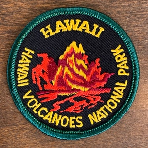 May include: A green and black embroidered patch with the text "Hawaii Volcanoes National Park" and a stylized image of a volcano erupting.