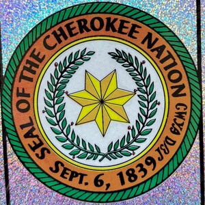 May include: Circular seal of the Cherokee Nation with a yellow starburst at the center, surrounded by a green wreath. The text "SEAL OF THE CHEROKEE NATION" and "SEPT. 6, 1839" are displayed in a circular pattern.