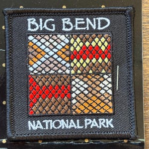 May include: Square black patch with the words "BIG BEND NATIONAL PARK" in white. The center features a grid of four squares with colorful diamond patterns in shades of brown, red, yellow, and blue.