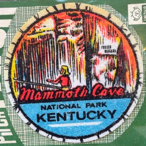 May include: A round, vintage Mammoth Cave National Park patch. The patch features a colorful illustration of a cave scene with a person in a boat, the text "Mammoth Cave" in red, and "Kentucky" in blue.